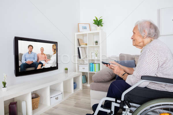 Fogyatékos nagymama néz film televízió tolószék Stock fotó © AndreyPopov