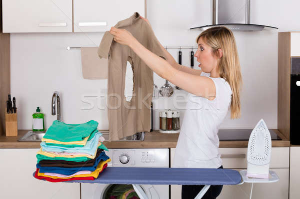 Shocked Woman Looking At Burnt T-shirt Stock photo © AndreyPopov