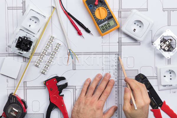 Architect Drawing Plan On Blueprint With Electrical Components Stock photo © AndreyPopov