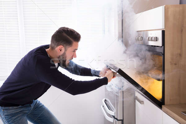 Shocked Man Looking At Burnt Cookies In Oven Stock photo © AndreyPopov