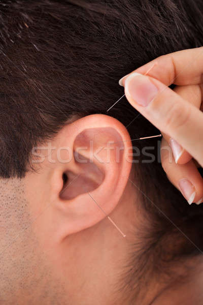 Person Holding Needle Near Ear Stock photo © AndreyPopov