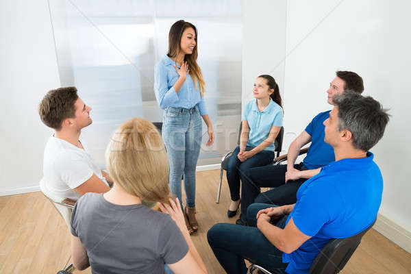 Vrouw uitleggen vrienden groep mensen naar glimlach Stockfoto © AndreyPopov