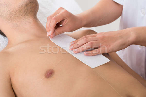 Person Hands Waxing Man's Chest Stock photo © AndreyPopov