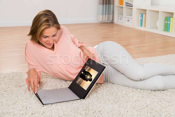 Donna guardando photo album sorridere soggiorno Foto d'archivio © AndreyPopov