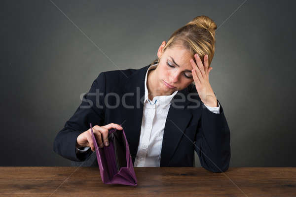 Sad Businesswoman Holding Empty Purse At Desk Stock photo © AndreyPopov