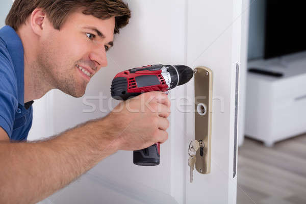 Happy Young Male Installing Door Lock Stock photo © AndreyPopov