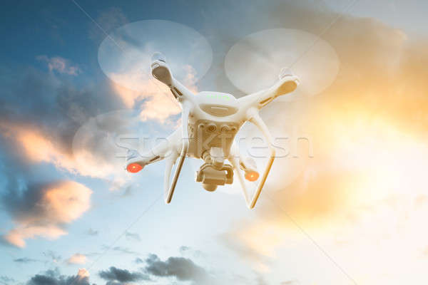 Drone flying against cloudy sky during sunset Stock photo © AndreyPopov