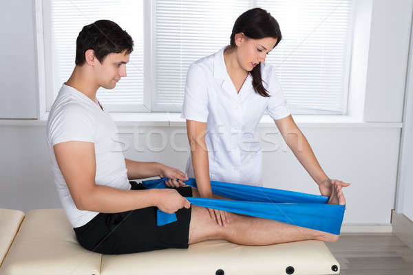Female Therapist Assisting Patient While Exercising Stock photo © AndreyPopov