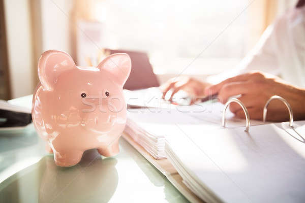 Close-up of a piggybank on reflective desk Stock photo © AndreyPopov