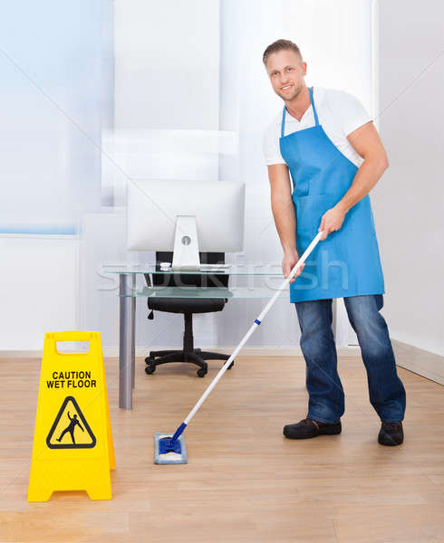 Warning notice as a janitor mops the floor Stock photo © AndreyPopov