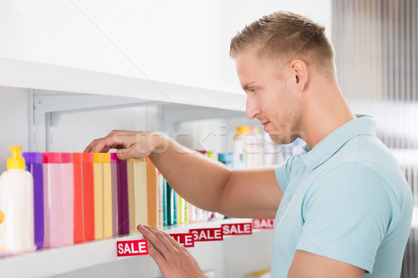 Male Customer Selecting Cosmetic Bottle Stock photo © AndreyPopov