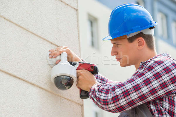 Young Male Technician Installing Camera On Wall Stock photo © AndreyPopov