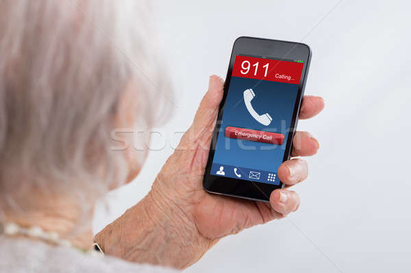 Senior Woman Dialing Emergency Call On Mobilephone Stock photo © AndreyPopov