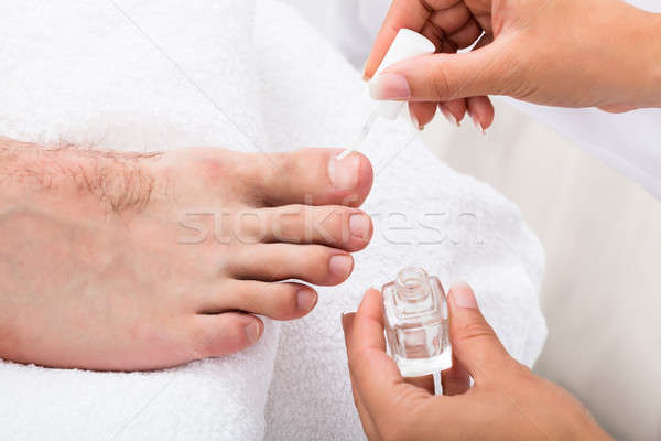 Manicurist Applying Moisturizing Oil On Person's Toenail Stock photo © AndreyPopov