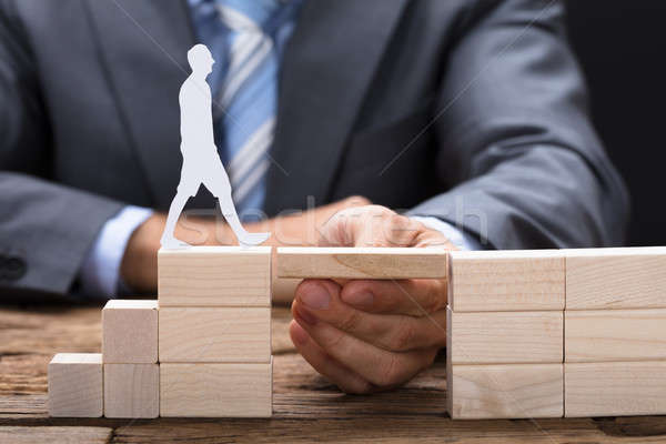 Hand Between Blocks With Paperman Walking On It Stock photo © AndreyPopov