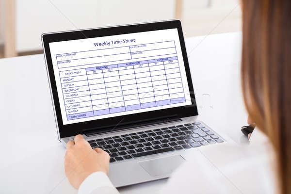 Businesswoman Filling Weekly Time Sheet Stock photo © AndreyPopov