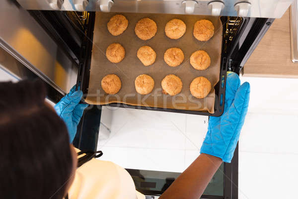 Human Hand Taking Out Tray Of Baked Cookies From Oven Stock photo © AndreyPopov