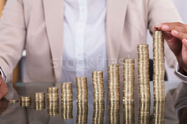 Businesswoman Hand Placing A Coin On Increasing Coin Stacks Stock photo © AndreyPopov