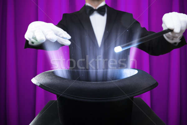 Bűvész tart varázspálca megvilágított kalap közelkép Stock fotó © AndreyPopov