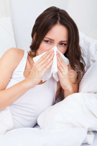 Jeune femme grippe lit infecté allergie moucher Photo stock © AndreyPopov