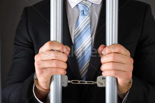 Handcuffed Businessman Holding Bars Stock photo © AndreyPopov