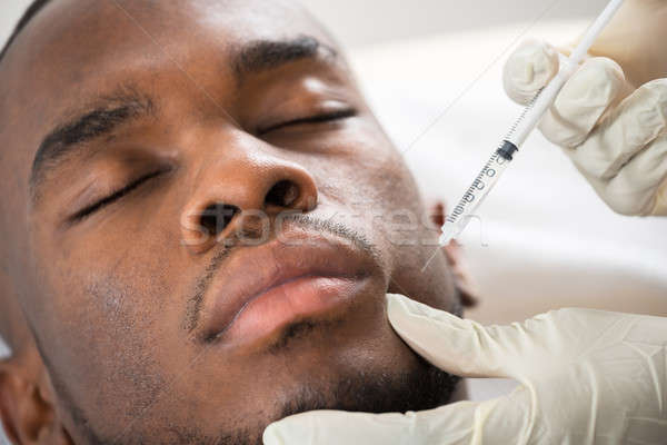 Person Hand Injecting Syringe On Young Man Face Stock photo © AndreyPopov