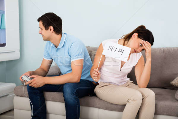 Upset Woman Sitting Beside A Man Addicted To Videogame Stock photo © AndreyPopov