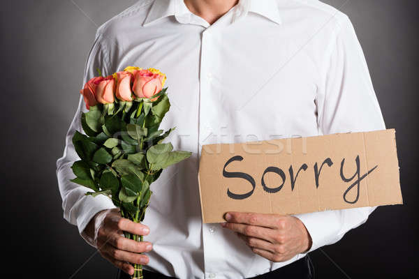 Man Holding Roses And Text Sorry Written On Cardboard Stock photo © AndreyPopov