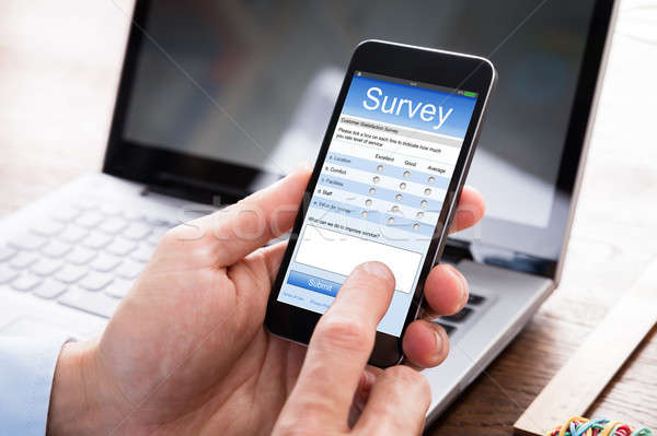 Businessman Filling Survey Form On Mobile Phone Stock photo © AndreyPopov