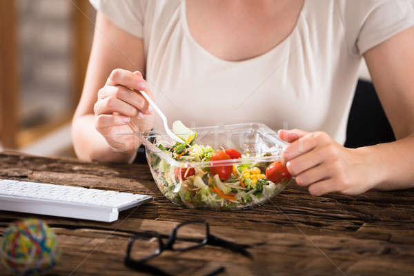 Mujer comer ensalada primer plano pausa para el almuerzo escritorio Foto stock © AndreyPopov