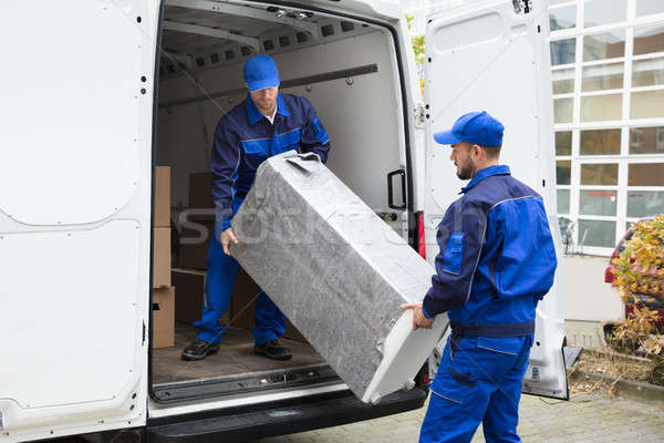 Stock photo: Two Delivery Men Unloading Furniture From Vehicle