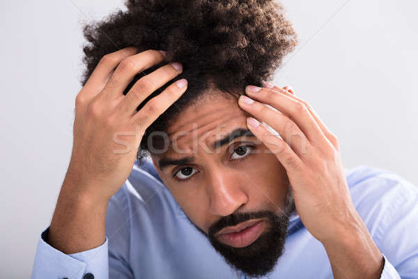 Férfi megvizsgál haj közelkép fiatalember arc Stock fotó © AndreyPopov