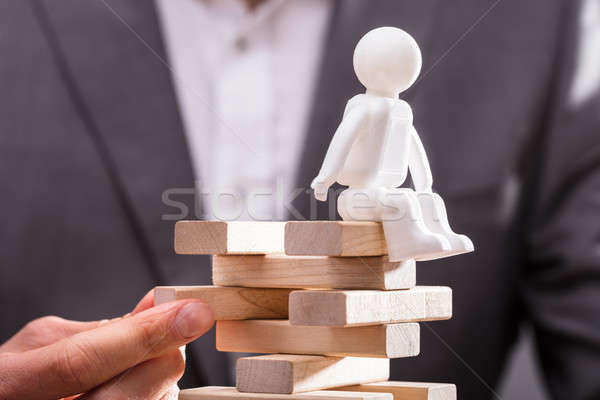 Human Figure Sitting On Top Of Stacked Wooden Blocks Stock photo © AndreyPopov