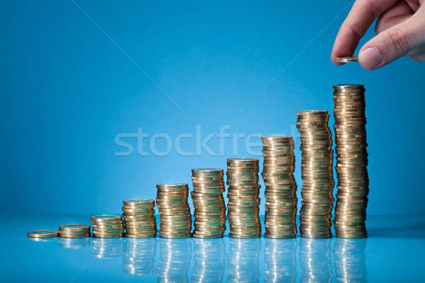 Hand Placing Coin On Stack Of Coins Stock photo © AndreyPopov