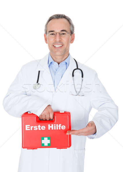 Happy male doctor carrying a portable first aid kit Stock photo © AndreyPopov