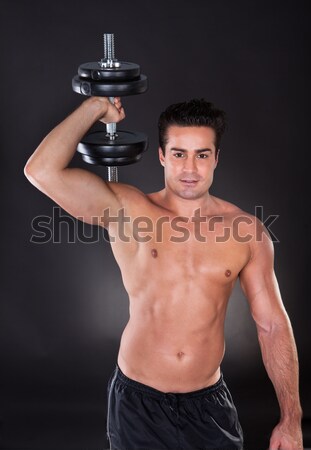 Stock photo: Muscular fit young man working out with weights