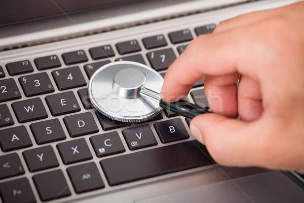 Hand Examining Laptop With Stethoscope Stock photo © AndreyPopov