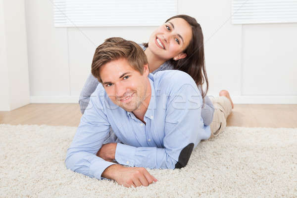 Loving Couple Lying On Rug In Living Room Stock photo © AndreyPopov
