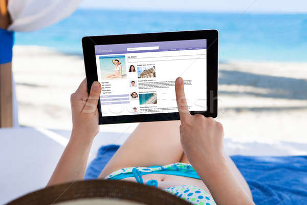 Woman Surfing On Social Site At Beach Stock photo © AndreyPopov