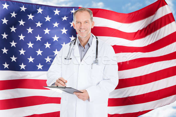 Glimlachend arts permanente Amerikaanse vlag hemel Stockfoto © AndreyPopov