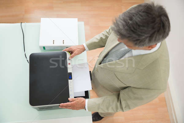 Mid-adult Businessman Using Photocopy Machine Stock photo © AndreyPopov