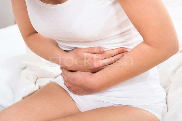 Nő szenvedés gyomorfájás közelkép ház kéz Stock fotó © AndreyPopov