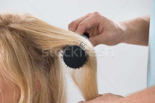 Hairstylist Brushing Woman's Hair Stock photo © AndreyPopov