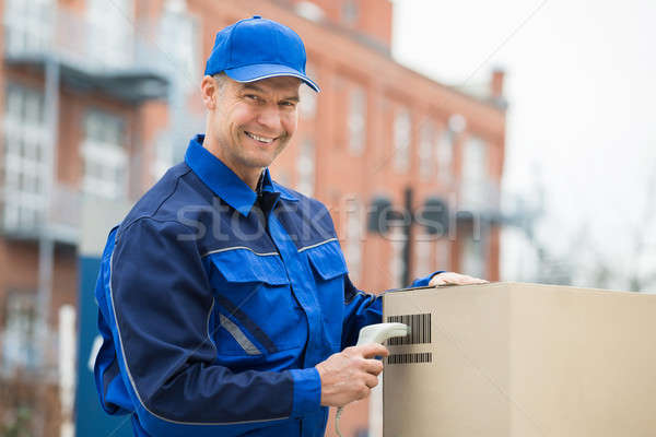 Stock photo: Delivery Man Scanning Cardboard Boxes With Barcode Scanner