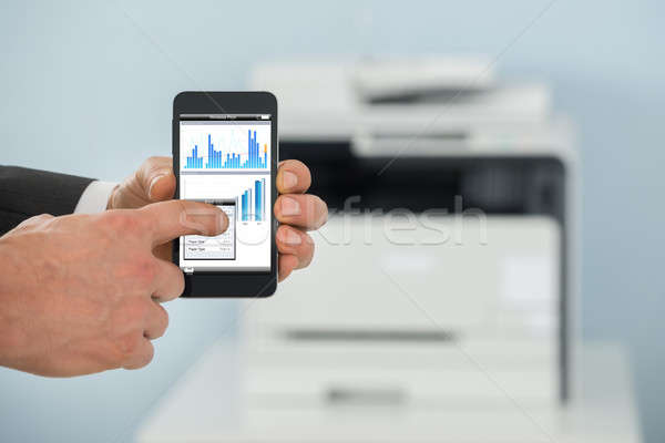 Businessman Using Cellphone For Printing Graph Paper Stock photo © AndreyPopov