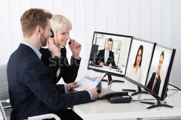 Businesspeople Video Conferencing On Desk Stock photo © AndreyPopov