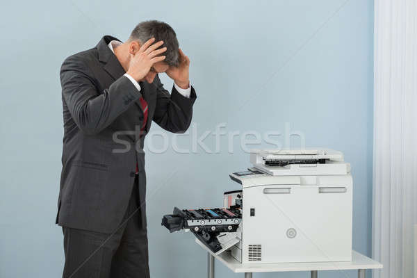 Businessman Looking At Printer Machine At Office Stock photo © AndreyPopov