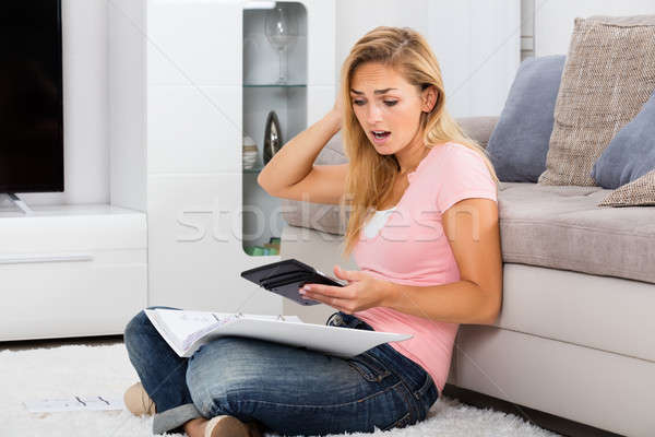 Frustrado mulher olhando calculadora jovem papel Foto stock © AndreyPopov