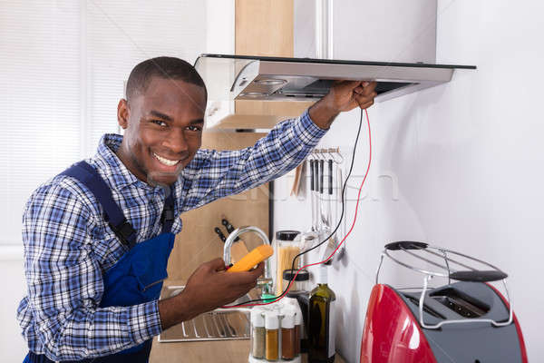 Handyman Checking Kitchen Extractor Filter Stock photo © AndreyPopov