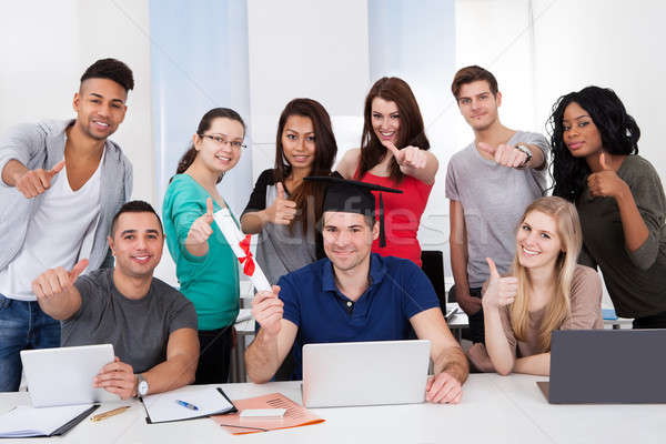 Student Holding Degree With Classmates Gesturing Thumbs Up Stock photo © AndreyPopov